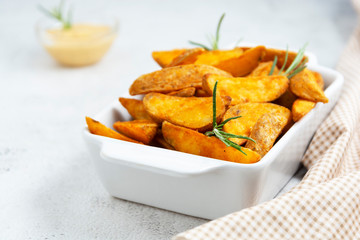 Fried potatos with herbs and sauce. Golden roasted potatoes, bright food photo.