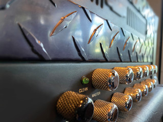 Close-up vintage head power amplifier with silver knob and black control panel. clean and hi-gain...