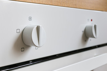 White electric oven switches. Control knobs for modern kitchen appliances