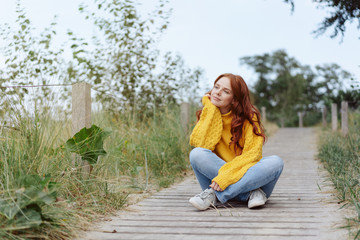 Thoughtful young woman relaxing in nature