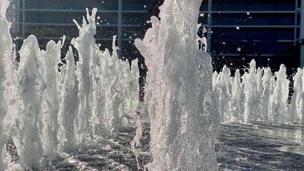 Side view of fountain, spraying upwards against dark background, taken with high shutter speed