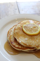 Lemon ricotta pancakes, stacked with syrup and lemon on top!