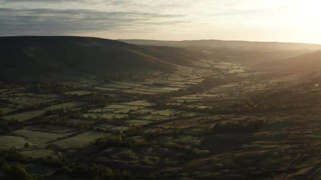 Beautiful slow moving aerial shot of the Peak District at sunrise