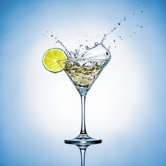 cocktail glass with a lime and splashes
