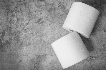 Top view of two rolls of toilet paper with copyspace on gray texture background