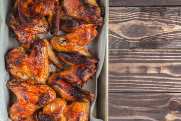 Baked chicken wings on a baking sheet, with a golden crispy crust. Place for text