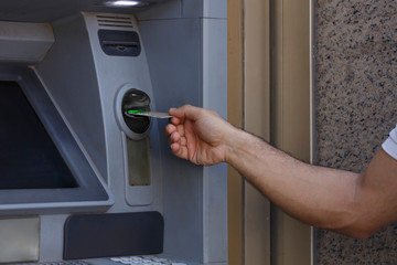 dettaglio delle mano del prelievo di denaro da un bancomat di una banca con una carta di credito.