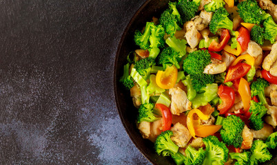 Stir-fry with chicken, broccoli and bell peppers. Top view close up.