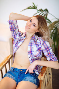 sexy beautiful girl with blond hair, topless unbuttoned plaid shirt and shorts