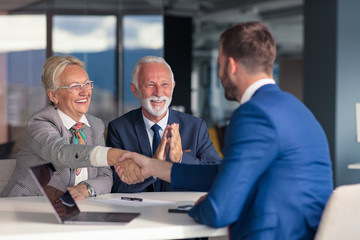 Positive aged couple consulting with insurance agent