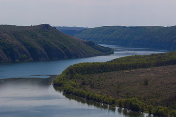 Fototapeta na wymiar Zigzag river flows between summer valleys. Dniester river