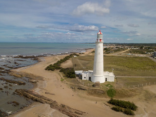 White lighthouse on the seashore on a sunny day.