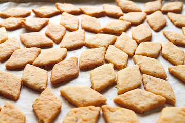 Freshly baked homemade cookies. A lot of hot fresh cheese pastry on a baking sheet. Selective soft focus.