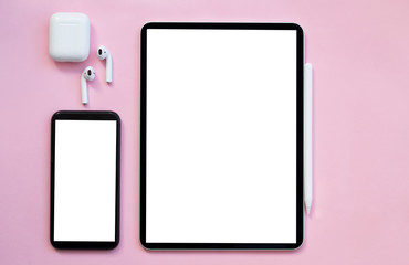 Telephone, Modern tablet, White wireless headphones are on a pink background.