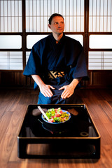 Traditional japanese room in house or ryokan restaurant with black lacquered wood table and salad...
