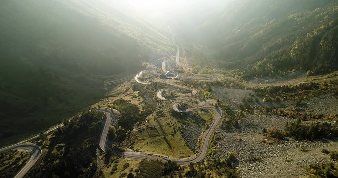 Beautiful road with harsh bends travels up valley through mountain range