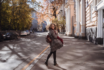 Portrait of beautiful brunette girl walking down the street.