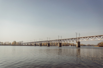 Fototapeta na wymiar walk to the Dnieper. view of the Petrovsky railway bridge from the Gorbachykha tract. Warm October, autumn