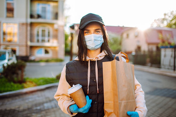 Health protection, safety and pandemic concept - delivery woman in protective face mask and gloves...
