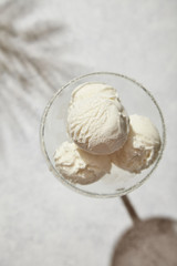Ice cream plombir in clear glass in bright sun