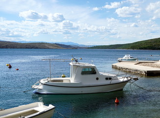 Fototapeta premium Boats in a small harbor in front of the bridge to the island of Krk in Croatia