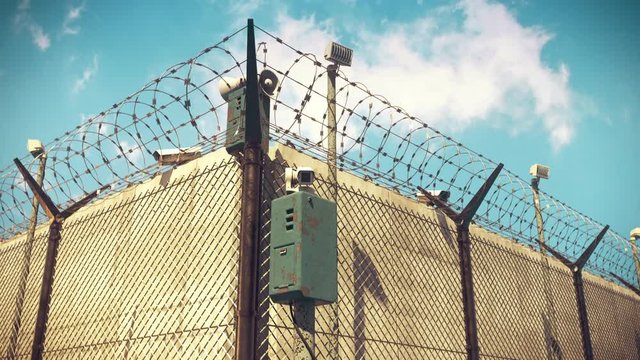 Security camera over barbed wire fence, CCTV footage, surveillance, penitentiary