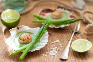 Obraz na płótnie Canvas Seared Scallops with Asparagus and Green Sauce Served in Shells