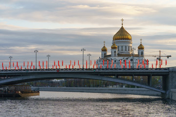 Fototapeta na wymiar Moscow cityscape in the spring day. Cathedral of Christ the Saviour. Coronavirus pandemic time. Nobody. Bolshoy Kamenny Bridge is decorated by red flags by the Victory Day celebration on May 9