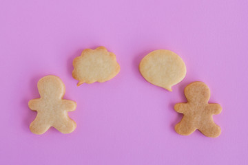 Homemade shortbread cookies on pink background, top view. Two people with callout bubble blank message.