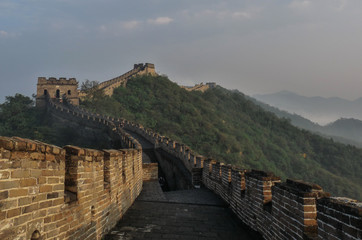 Great wall of China at sunny day. Amazing view of Great Wall at good weather. Mountain view in China with fog. Ancient historical wall near the beautiful landscape. Chinese people. Tourism in China.