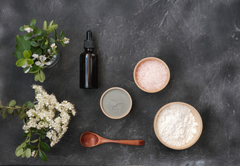 making clay mask at home, ingredients for mask for clean and smooth skin. essential oil, clay and pink salt on a trendy grey background. top view. flat lay. homemade exfoliating mask.