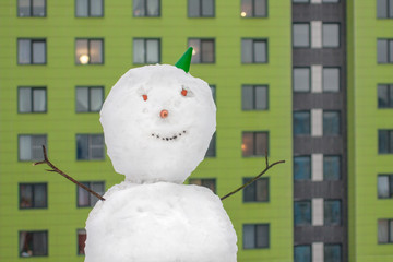 Smiling snowman with city builing in background