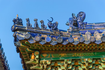 Richly decorated roofs of a Chinese temple, small colorful details with figurines.