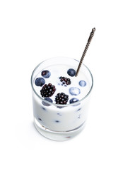 Drinking yogurt with fresh berries in a glass isolated on white