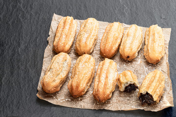 Homemade baked mini chocolate filled churros on black stone background