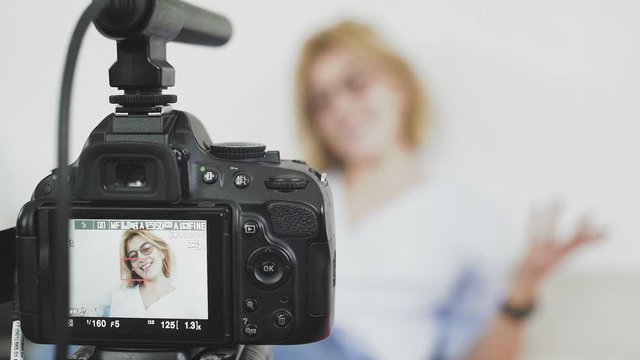 Female blogger is turning on the camera and strating recording video