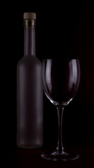 Wine glasses on black backround and wine bottles