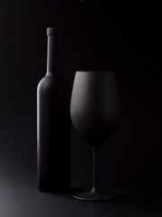 Wine glasses on black backround and wine bottles