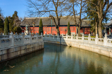 The moat between the buildings is separated by white stone fences.
