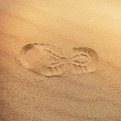 Fototapeta na wymiar footprint with tread shoes on a sandy surface