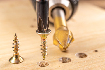 Screwing metal screws into chipboard for furniture construction. Small carpentry work in the home...