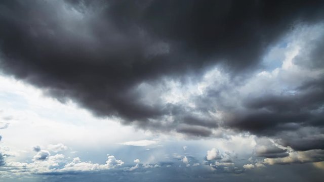 Picturesque aerial timelapse of stormy clouds gradually covering the sky against pure sunshine until the view is completely overtaken by the dark. 