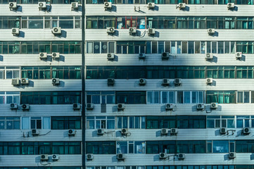 Wall of a block of flats, numerous air conditioners mounted outside the flat.