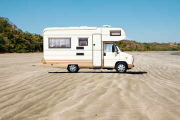old camping bus, rv camper van at beach  -