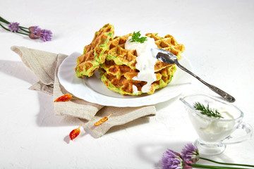 Proper breakfast, healthy Belgian waffles from zucchini with sour cream. On white background.