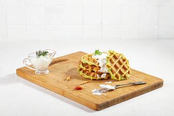 Proper breakfast, healthy Belgian waffles from zucchini with sour cream. On white background.