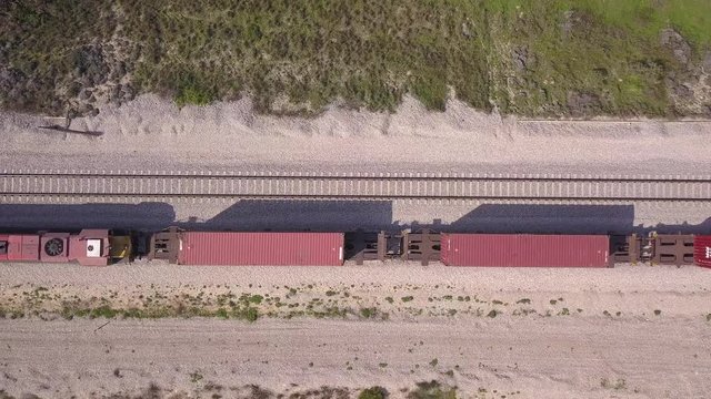 Freight Train crossing the frame In high speed, Top down aerial view.