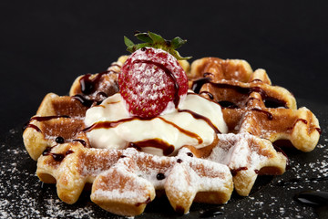 Viennese waffles with strawberries, black currants, blackberries, topped with chocolate, whipped cream and powdered sugar.