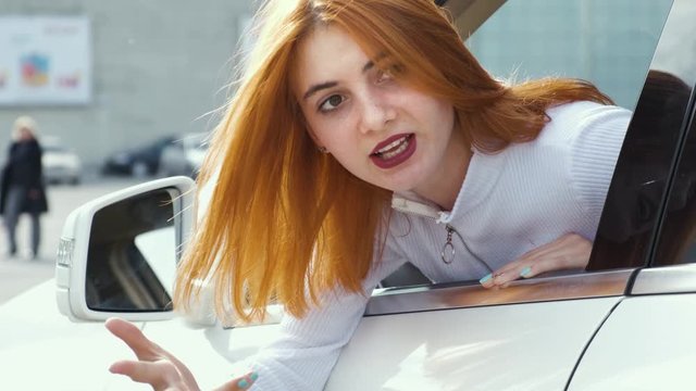 Closeup portrait of pissed off displeased angry aggressive woman driving a car backwards shouting at someone. Negative human expression and road rage consept.