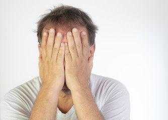 Middle-aged man with white T-shirt and quarantined boredom. Altered concentration and tiredness at home office.